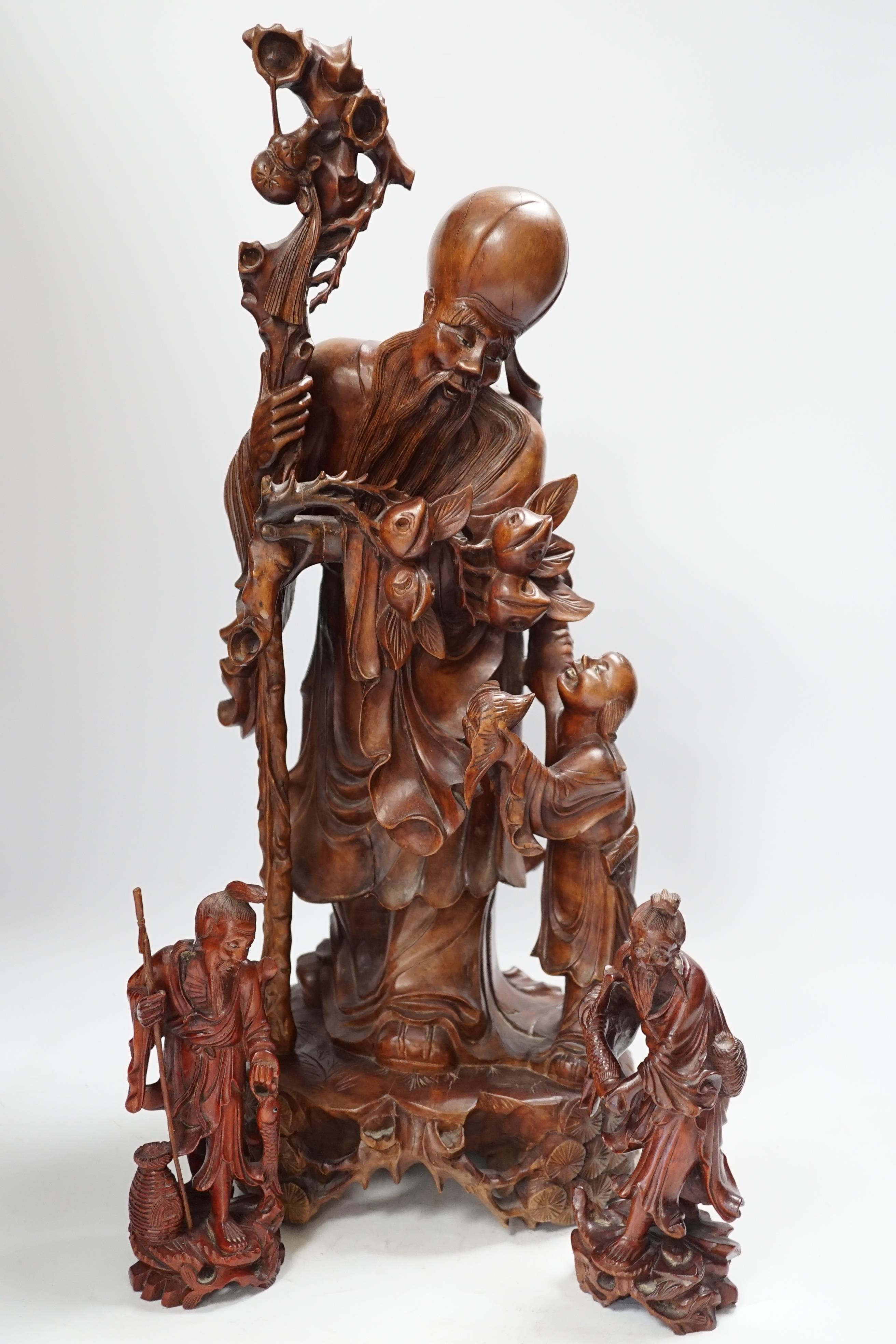 A large Chinese carved wooden figure group of Shou Lao and a pair of small carved figures, figure group 52cm high